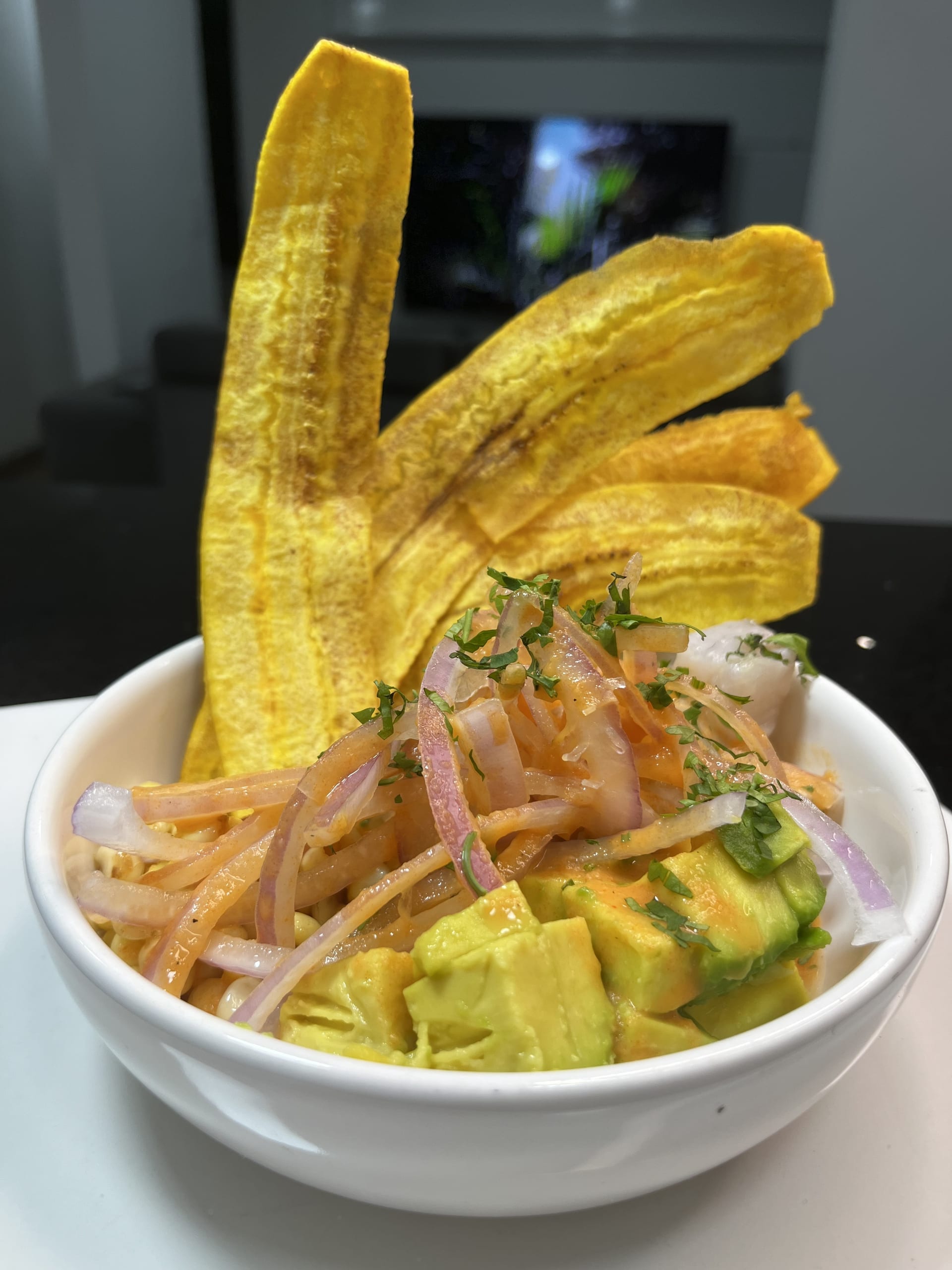 Bowl de ceviche con aguacate y chifles preparado por Raíz C&C