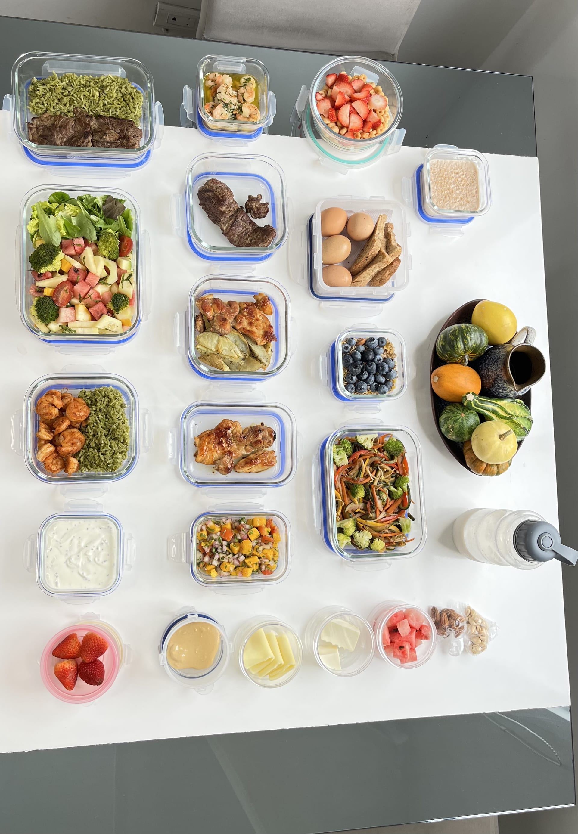 Comidas de meal prep organizadas en recipientes de vidrio